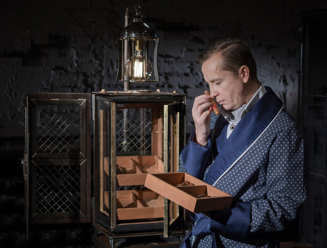 A man admiring the best humidor cabinet on the market that has several pull out Spanish cedar shelves.