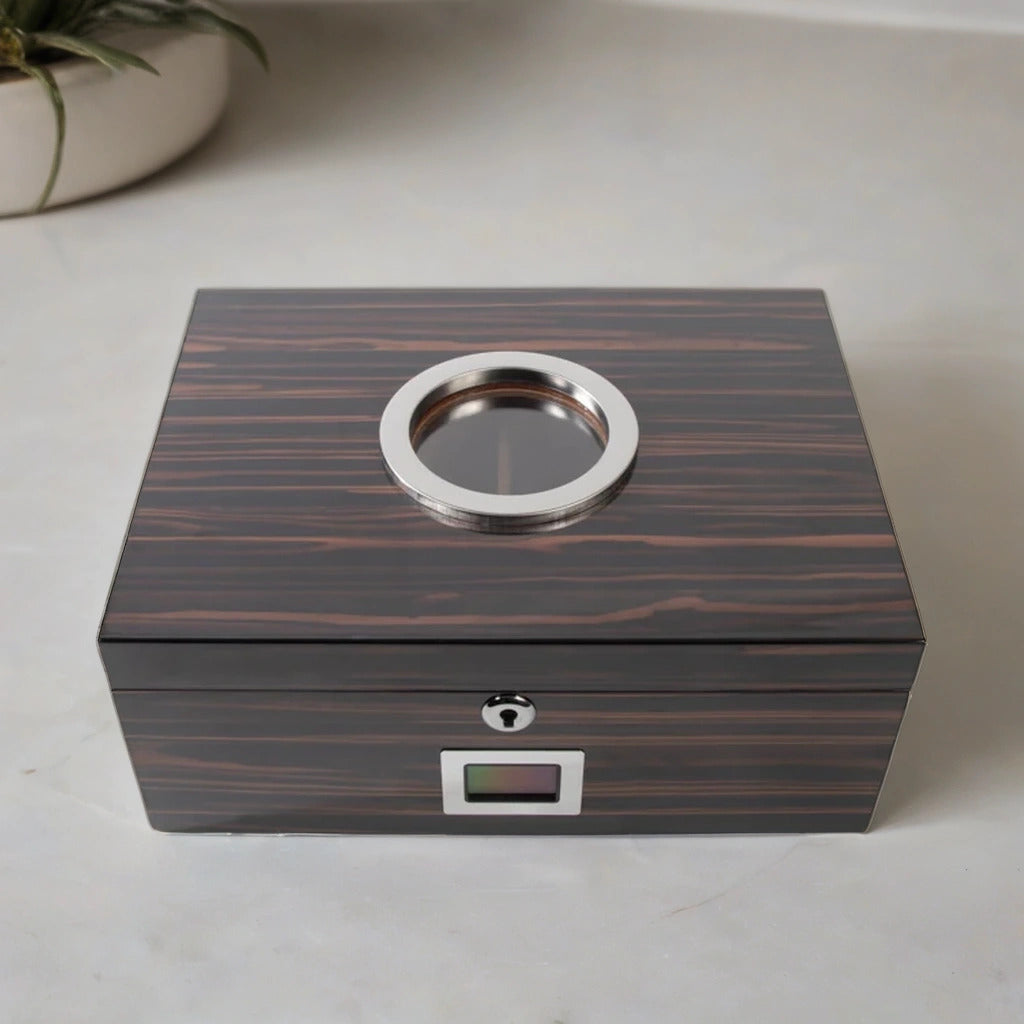 Luxury desktop cigar humidor with an ebony wood finish, glass window on the top, and silver plated hardware