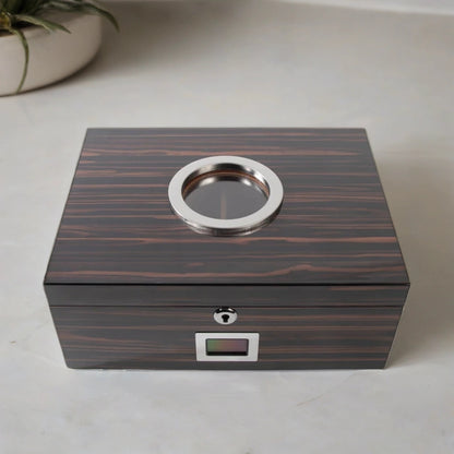Luxury desktop cigar humidor with an ebony wood finish, glass window on the top, and silver plated hardware