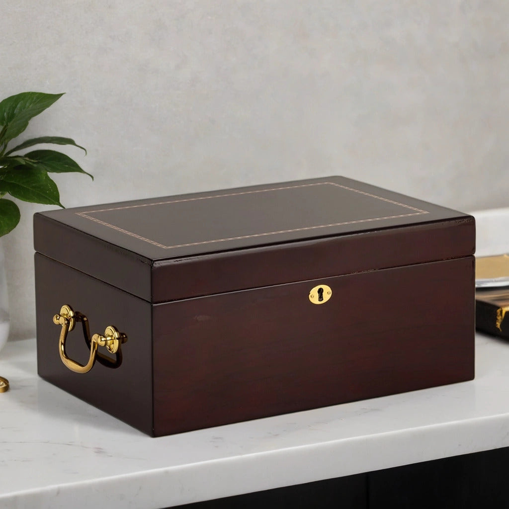 Brown desktop humidor box with gold handle and lock on a white surface