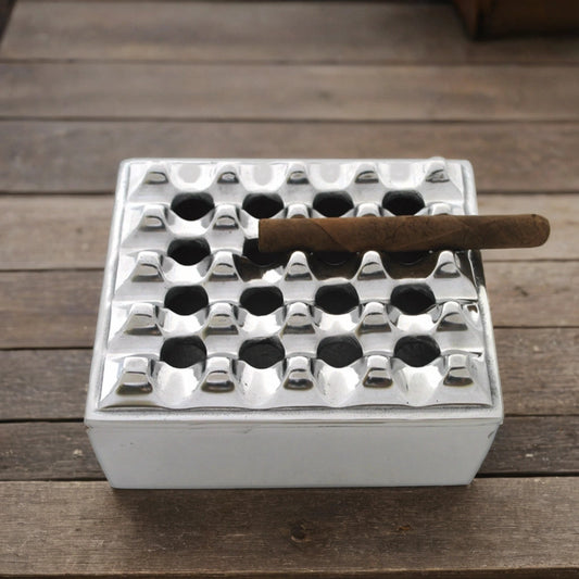 Metal outdoor cigar ashtray on a weathered wooden table.