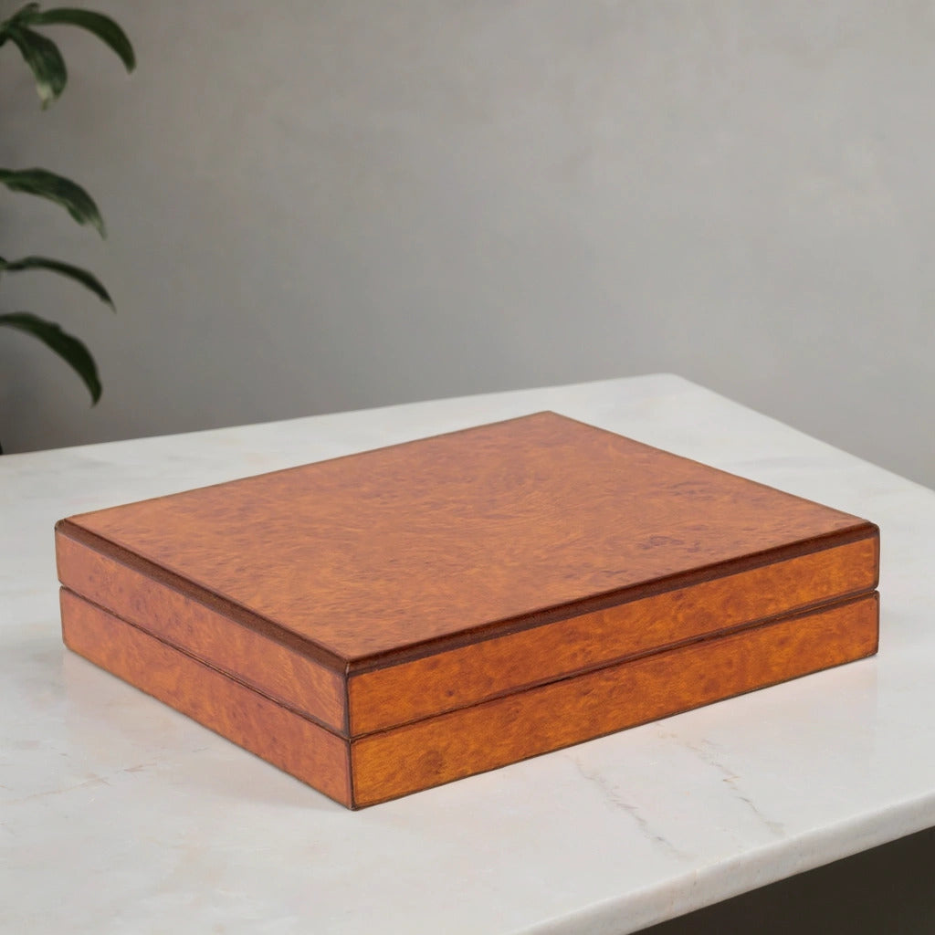 Burl finish cigar humidor on a white surface with a gray background