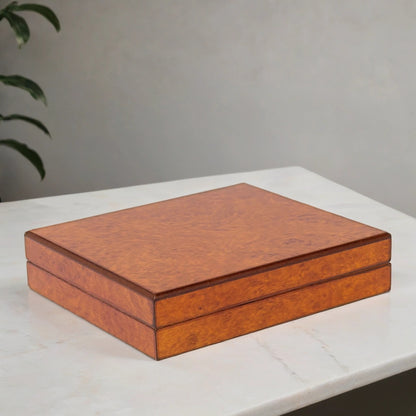 Burl finish cigar humidor on a white surface with a gray background