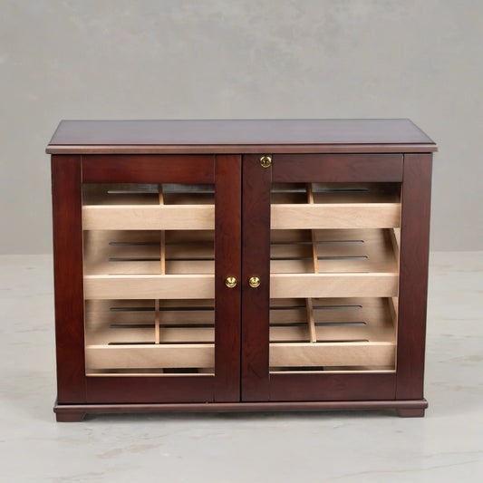 Wooden countertop display humidor with three shelves and glass doors on a light gray background