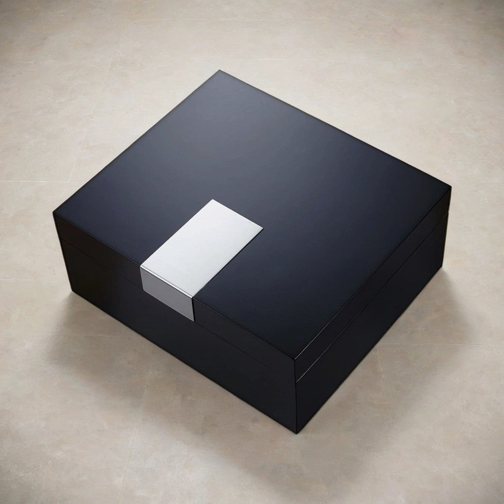 Black rectangular desktop humidor with silver accent on a beige surface