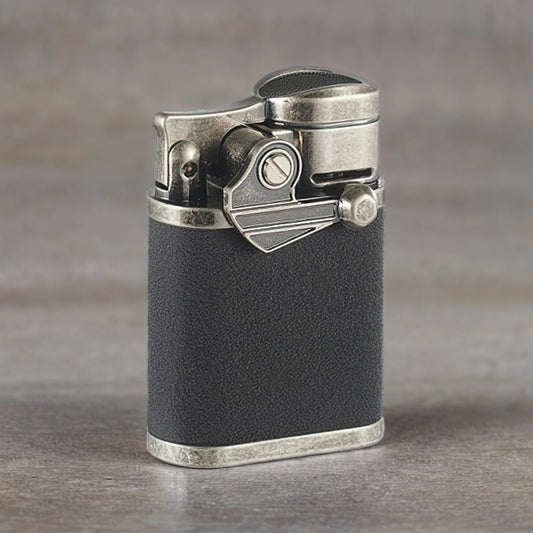 Vintage-style cigar torch lighter with black finish sitting on a wooden surface