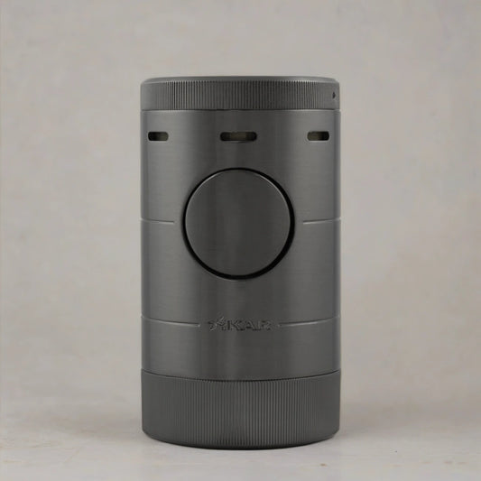 Tabletop cigar lighter with a gunmetal grey finish sitting flat on a neutral toned surface